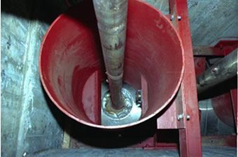 Protective wall installed to cut reactor core spray piping with a shaped explosive